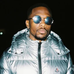 photo, black man, silver metallic moncler jacket, silver reflective circular sunglasses, head and shoulders portrait, night, cinestill 8 0 0