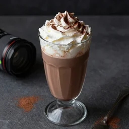 food photography of hot chocolate drink in tall glass with cream on top and cocoa powder, canon macro lens, moody lighting, hdr
