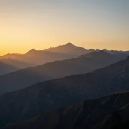 an amazing photograph of a mountain range, the setting sun is shining on the peaks of the mountains