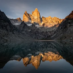award winning landscape photography, mirror reflection lake in foreground with jagged highland mountains in background, beautiful morning light, dramatic lighting, ultra wide angle