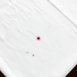 top view of a white tablecloth with some small red wine stains