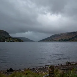 a photograph of a scottish loch on a stormy day, high quality, highly detailed, award winning landscape photography, dramatic lighting, stormy skies, ominous clouds, fujifilm, foreground interest, f 1 6