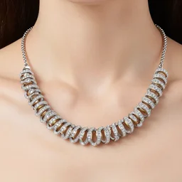 catalog photograph of a woman's necklace in white gold. the necklace sparkles around the model's neck. the necklace is made up of lots of small gold rings encrusted with precious stones.