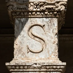 A single uppercase letter 'S' carved into a roman inscription, trajan's column, detail