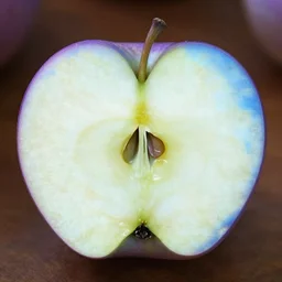 an apple cut into two equal-sized pieces, one piece has purple skin and one piece has blue skin