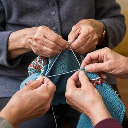 a beautiful photograph of an elderly woman’s four hands as she’s crochets an Afghan, her four hands are highly realistic and accurate