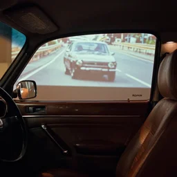 fuji 5 0 r, tilt sift ; monaco film still of beetle style car interior with front seat side window view ; in background a projection of beautiful hyperrealistic film still from ronin ( 1 9 9 0 ) car chase scene directed by wes anderson instyle of 1 9 9 0 s frontiers in miniature porcelain kintsugu design magazine seinen manga edition, real - life seinen manga porcelain sci - fi font izakaya sign, highly detailed, cinematic lighting, 8 k