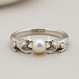 “thin sterling silver ring with a small pearl in the middle, the prongs holding the pearl are the fingers of two frogs, one long frog stretched out on the right and another stretched out on the left, high quality product image”