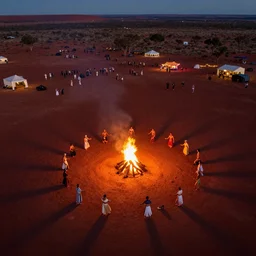 atmospheric stunning night aerial drone photograph of festival dancers on the edge of the red australian desert at night, bonfire, accurate bodies, campsites, diverse costumes, 8 k, ultra clear detailed