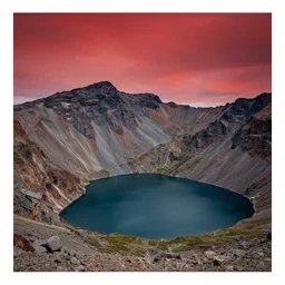 mountain with a lake and a red sky