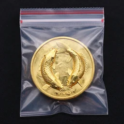 Golden coin with koi fish etching on it inside a plastic ziplock bag —H 1024