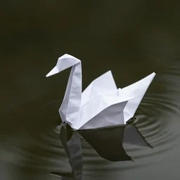 origami swan floating on dark water